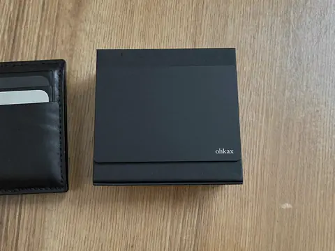 Tarjeta ohkax sobre su caja junto a una cartera