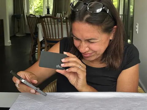 Mujer vinculando la tarjeta ohkax con su celular